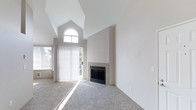 The Cape offers a thoughtfully designed 2-bedroom, 2-bathroom single-floor residence that combines comfort with architectural character. The living area immediately impresses with soaring vaulted ceilings that create a dramatic sense of openness and volume. A striking arched window sits high on the wall, drawing in generous natural light that fills the space throughout the day. Large vertical-blind-covered sliding doors provide access to the outdoors while further enhancing the bright, airy atmosphere. A tile-surround fireplace serves as a handsome focal point in the living area, adding warmth and a classic design element to the room. The soft, neutral carpeting throughout complements the crisp white walls, lending the space a clean and welcoming ambiance. The overall palette is light and understated, allowing the architectural details — particularly the dramatic ceiling lines and arched window — to take center stage. With two full bathrooms and two bedrooms, this residence offers a functional and comfortable layout well-suited for a variety of living arrangements. The combination of distinctive design features and an abundance of natural light makes this home at The Cape a standout offering.