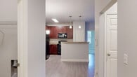 Located at 405 Grand Wailea Dr in Fayetteville, NC, this single-story 2-bedroom, 2-bathroom home offers a thoughtfully designed layout with a comfortable and functional flow. The open-concept living, dining, and kitchen area serves as the heart of the home, featuring light wood-look flooring and a modern chandelier over the dining space. The kitchen is equipped with rich cherry-toned cabinetry, granite-look countertops, black appliances including a refrigerator, range, and microwave, and a peninsula island with pendant lighting that provides additional prep and seating space. A pantry adds extra storage convenience. Both bedrooms are carpeted and include ceiling fans, providing comfort year-round. The generously sized primary bedroom connects to its own bathroom and features access to a walk-in closet outfitted with wire shelving and hanging rods. A dedicated laundry room with washer and dryer hookups adds practicality. With six closets throughout, storage is plentiful. Neutral tones, clean white trim, and consistent finishes create a cohesive and move-in ready aesthetic across the entire home.