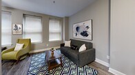 Located at 10 S Main St in the heart of downtown Memphis, Tennessee, this one-bedroom, one-bathroom residence offers a well-designed layout across a single floor. Hardwood-style flooring runs throughout, complemented by neutral gray walls and crisp white trim that create a clean, contemporary aesthetic.

The open-concept living, dining, and kitchen area serves as the centerpiece of the home. The kitchen features white cabinetry, a stainless steel refrigerator, light stone countertops, and a breakfast bar with seating — ideal for casual dining. The living area benefits from multiple windows that allow natural light to fill the space, and a ceiling fan adds comfort overhead.

A dedicated hallway connects the main living space to the private bedroom, which includes multiple windows, a ceiling fan, ample closet storage, and a calm, neutral palette. The full bathroom is outfitted with white cabinetry, a wide vanity with stone-look countertops, a large mirror, and a shower/tub combination.

Additional highlights include a laundry area, utility room, three closets, and a dedicated entrance. The overall ambiance is modern and understated, with thoughtful finishes that balance style and functionality in an efficient, well-organized floor plan.
