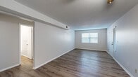 Located at 700 E 100th Terrace in Kansas City, Missouri, this single-floor residence offers a well-organized layout with a clean, neutral aesthetic throughout. The main living areas feature durable wood-look plank flooring that runs consistently through the living room, dining area, and connecting spaces, creating a cohesive and easy-to-maintain environment. The living room is bright and open, benefiting from natural light through blinds-fitted windows, a ceiling fan with integrated lighting, and a textured ceiling that adds depth to the space.

The galley-style kitchen is efficiently designed with white cabinetry, granite-look countertops, a full suite of white appliances including a coil-top range, refrigerator, and dishwasher, along with ample upper and lower cabinet storage.

The bedrooms are carpeted for comfort, each offering natural light via windows with blinds. The primary bedroom includes multiple closets, providing generous storage. Additional bedrooms also feature closet access, making them versatile for various uses.

The bathroom is neatly appointed with a white vanity, granite-look countertop, a medicine cabinet mirror, and wood-look flooring. Throughout the unit, neutral gray-toned walls, white trim, and consistent finishes contribute to a bright, move-in-ready atmosphere.