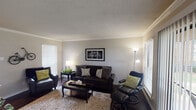 Located at 2450 State Hwy 121 in Bedford, Texas, this single-floor residence offers a well-organized layout with distinct living, dining, kitchen, bedroom, and bathroom spaces. The living room serves as the heart of the home, showcasing rich dark hardwood flooring, crown molding, and a textured ceiling. Multiple windows fitted with horizontal blinds allow natural light to fill the space, while a sliding glass door with vertical blinds provides access to the outdoors. The adjacent dining area features recessed lighting, continued hardwood flooring, and a bright window that further brightens the room. The kitchen is thoughtfully designed with granite countertops, a double undermount sink, white cabinetry, a dark tile backsplash, and a full suite of stainless steel appliances, including a refrigerator, range, and microwave. The bedroom offers plush carpeting, a ceiling fan with light fixture, and a window that admits soft natural light, creating a comfortable and restful environment. The bathroom includes a granite-topped vanity, dark hardwood flooring, and a tub-shower combination with classic white subway tile accented by a dark border stripe. Throughout the residence, crown molding and consistent finishes lend a cohesive and polished character to every room.