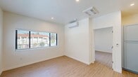 Located at 201 River Street in Santa Cruz, California, this thoughtfully designed one-bedroom, one-bathroom unit offers a clean, modern aesthetic across a compact and efficiently utilized floor plan. Light wood-style flooring runs throughout, complementing the crisp white walls and recessed lighting that give every room a bright, airy feel.

The living room features large windows fitted with blinds, allowing abundant natural light to fill the space while offering views of the surrounding neighborhood. A wall-mounted mini-split system in the bedroom ensures year-round climate comfort, while sliding glass doors open directly onto a private balcony with decorative iron railings and open views of the Santa Cruz streetscape under expansive California skies.

The kitchen is a standout feature, outfitted with sage-blue shaker-style cabinetry, white countertops, and a full suite of stainless steel appliances including a gas range, over-the-range microwave, dishwasher, and refrigerator. The bedroom is a well-proportioned retreat with a dedicated closet for storage. The bathroom is finished with elegant marble-style tile surrounding a full soaking tub and shower combination, accented by oil-rubbed bronze fixtures. The overall ambiance is modern, clean, and move-in ready.