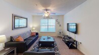 Located at 25 Landis Ln in Lillington, NC, this single-floor unit offers a well-organized layout designed for comfortable everyday living. The kitchen is fully equipped with warm honey-toned wood cabinetry, ample counter space, a double-basin stainless steel sink, and a full suite of black appliances including a refrigerator, electric range, microwave, and dishwasher. Wood-style plank flooring runs through the kitchen and dining area, creating a clean transition into the carpeted living spaces. The living room is a comfortable, open gathering space featuring a ceiling fan, a window that brings in natural light, and enough room for a full seating arrangement. Two well-proportioned bedrooms, each finished with plush carpet, ceiling fans or overhead lighting, and windows overlooking the outdoors, provide restful retreats. Both bathrooms are efficiently designed, featuring warm wood vanities with white countertops, tile flooring, and clean white walls. The full bathroom includes a shower-tub combination. A dedicated laundry room adds everyday convenience, completing this practical and move-in-ready floor plan.