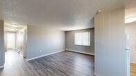 Located at 3780 Rebecca Ln in Colorado Springs, Colorado, this 2-bedroom, 1-bathroom residence offers a practical and well-organized single-floor layout. The living room is a welcoming open space featuring wood-style laminate flooring, neutral gray walls, a textured ceiling, a ceiling fan, and a baseboard heating unit. A window with vertical blinds allows natural light to fill the room, while a wall-mounted AC unit provides additional climate control. The galley-style kitchen is efficiently designed with dark wood cabinetry, light stone-patterned countertops, a stainless steel sink, and white appliances including a refrigerator and electric range, all set on light wood-style flooring. Both bedrooms are carpeted for comfort and feature textured ceilings and neutral tones. The primary bedroom includes a ceiling fan and a window with vertical blinds, while the second bedroom offers a closet with built-in shelving. Hallways connect the rooms seamlessly throughout the layout. The bathroom is bright and clean, featuring a tub-shower combination, a window for natural ventilation, wood-style flooring, and a vanity with matching countertops. Baseboard heating is present throughout the home, ensuring year-round comfort.