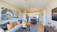 Located in San Diego's vibrant North Park neighborhood, this single-floor residence offers a thoughtfully designed open-concept layout with modern finishes throughout. Light wood-tone flooring flows seamlessly across the living, dining, and kitchen areas, creating a cohesive and inviting atmosphere.

The living room is bright and airy, featuring large windows and a sliding glass door that opens to a private balcony with sweeping views of the surrounding neighborhood and palm tree-lined skyline. The kitchen is well-appointed with white shaker cabinetry, stainless steel appliances including a French door refrigerator, a microwave, an electric range, and a dishwasher. A pendant-lit dining table anchors the space between the kitchen and living area, ideal for entertaining.

The unit includes two comfortably sized bedrooms, each featuring large windows that bring in ample natural light and offer outdoor views. Both bathrooms are clean and functional, featuring white vanities and light wood flooring — one with a shower/tub combination and one designed as a half bath.

The overall design palette is neutral and contemporary, with warm beige walls and recessed lighting enhancing the bright, open feel of the home. This well-appointed residence combines comfort and modern style in one of San Diego's most sought-after urban neighborhoods.