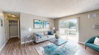 This efficiently designed 1-bedroom, 1-bathroom single-floor residence offers a thoughtful layout across a compact yet functional footprint. The living room serves as the heart of the space, featuring wood-style flooring, neutral-toned walls, and a large sliding glass door that fills the area with natural light while providing direct access to an outdoor area with views of surrounding greenery. The open sightline from the entry hallway extends into a dedicated dining area, complete with a ceiling fan and additional wall art, creating a welcoming flow throughout the unit. The kitchen is well-equipped, showcasing dark espresso cabinetry, granite-style countertops, a classic subway tile backsplash, stainless steel sink, dishwasher, and electric range alongside a full-size refrigerator — all set on matching wood-style flooring. The bedroom is generously proportioned, offering a large window with natural light, hardwood-style flooring, and convenient access to both a closet and the bathroom. The bathroom includes a vanity with under-cabinet storage, a lighted mirror, and notably, an in-unit stacked washer and dryer, adding practical convenience. Textured ceilings are consistent throughout, lending the space a classic residential character.