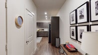 This thoughtfully designed single-floor residence offers a seamless blend of modern finishes and functional living spaces. The open-concept kitchen is a standout feature, showcasing rich dark cabinetry, light granite countertops, a classic white subway tile backsplash, stainless steel appliances, and a spacious island with pendant lighting and bar seating — ideal for both cooking and entertaining. The kitchen flows directly into the living area, which is bright and welcoming, with recessed lighting, wood-look flooring, and multiple windows allowing generous natural light and outdoor views. A dedicated entryway hallway provides a clean transition into the home. The bedrooms offer comfortable retreats, each featuring plush carpet, ample natural light through sizable windows with blinds and drapes, and ceiling fans. Two full bathrooms serve the residence, each finished with dark cabinetry, granite vanity tops, wood-look flooring, and tub-shower combinations with tile surrounds. Industrial-style light fixtures add a contemporary touch. Throughout the home, a consistent palette of neutral tones, warm wood floors, and modern hardware creates a cohesive and inviting atmosphere well-suited for everyday living.