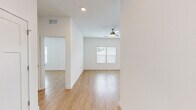Located at 5901 Myrtle Dr in Wildwood, Florida, this single-story 2-bedroom, 2-bathroom home offers a bright and modern interior defined by a consistent neutral color palette and light wood-style flooring throughout. The open-concept living room flows naturally from the kitchen and dining area, featuring a ceiling fan and natural light from blinds-covered windows that offer views of the surrounding landscape.

The kitchen is a standout feature, outfitted with crisp white shaker-style cabinetry, stone countertops, a central island, and a full suite of stainless steel appliances including a range, microwave, dishwasher, and refrigerator. A window above the sink adds natural brightness to the workspace.

The primary bedroom is a comfortable retreat with a ceiling fan, dual windows, and direct access to an en-suite bathroom. The primary bath includes a white vanity with stone countertops, large-format tile flooring, and a glass-enclosed walk-in shower. A dedicated walk-in closet with built-in shelving and a small window provides generous storage. The second bedroom is equally well-lit, with matching flooring and a ceiling fan. The second full bathroom mirrors the home's clean aesthetic with a vanity, tiled floors, and a window for natural ventilation.