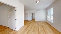 Located in Liberty Lake, WA, this well-appointed 2-bedroom, 2-bathroom residence offers a thoughtfully designed single-floor layout with a clean, contemporary aesthetic. Light-toned hardwood-style flooring runs throughout the entire unit, creating a cohesive and airy feel.

The kitchen is a standout feature, showcasing two-toned cabinetry in soft blue-gray and white, stainless steel appliances including a refrigerator, range, microwave, and dishwasher, and light countertops with a clean tile backsplash. Recessed lighting and an open sightline into the living area make this space both functional and inviting.

The open living area benefits from natural light streaming through large windows with views of the surrounding neighborhood. A wall-mounted mini-split unit provides efficient climate control. Both bedrooms are bright and comfortable, each featuring windows that bring in natural light. The primary bedroom includes a dedicated walk-in closet outfitted with wire shelving for organized storage. Both bathrooms are finished in a clean, minimalist style, each featuring a full bathtub and shower combination, light flooring, and simple, functional fixtures. The overall design is modern, neutral, and move-in ready.