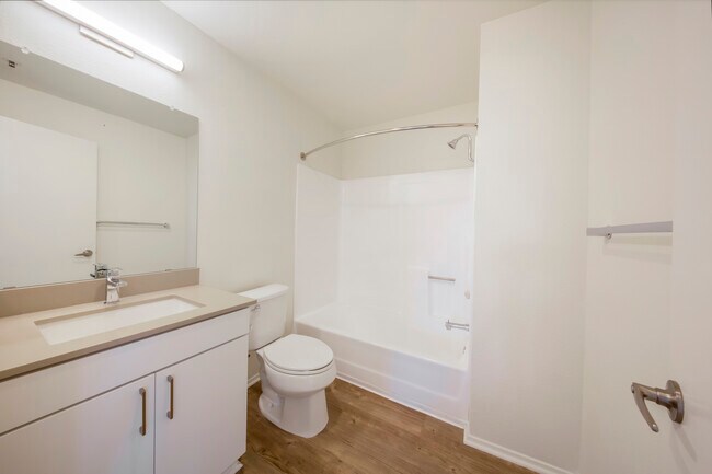 Paquete de baño renovado con gabinetes blancos, encimera de cuarzo gris y piso de superficie dura. - eaves La Mesa