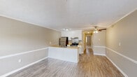 Located at 501 Leisure Lake Dr in Warner Robins, Georgia, this one-bedroom, one-bathroom unit offers a practical and well-organized single-floor layout. The open-concept living and kitchen area serves as the heart of the home, where light hardwood-style flooring, a textured ceiling, and crown molding lend a clean, cohesive look throughout. The living room benefits from multiple windows and a glass exterior door that bring in generous natural light, and a ceiling fan adds comfort to the space.

The kitchen is designed for functionality, featuring a peninsula with a butcher block-style countertop and an integrated sink, white cabinetry, a stainless steel refrigerator, and an electric range with a ventilation hood. Ample counter space and under-cabinet storage make this an efficient cooking area.

A hallway connects the main living space to the private bedroom, which is carpeted and outfitted with a ceiling fan, a closet with open shelving, and neutral-toned walls that create a calm, restful atmosphere.

The bathroom is clean and straightforward, offering a tub-shower combination, a single-sink vanity with a mirror, and a toilet — all finished in neutral tones. The layout is compact yet fully functional, making efficient use of every square foot in this well-maintained unit.