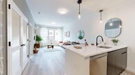 Located at 100 Hale Ave in White Plains, NY, this thoughtfully designed 2-bedroom, 1-bathroom residence offers a modern aesthetic complemented by quality finishes throughout. The open-concept layout seamlessly connects the kitchen and living room, creating an inviting, functional space ideal for everyday living.

The kitchen is a standout feature, boasting sleek dark cabinetry, a white quartz waterfall peninsula with bar seating, stainless steel appliances, a matte black faucet, and elegant pendant lighting overhead. Light wood flooring flows consistently throughout the home, adding warmth and cohesion.

The living room receives generous natural light through large windows dressed with sheer curtains, creating a bright, airy atmosphere with views of the surrounding neighborhood. The primary bedroom is a comfortable retreat, featuring a dedicated window with natural light, soft neutral tones, and a wall-mounted climate control unit. A walk-in closet provides ample storage.

The bathroom is finished with large-format neutral floor tiles, dark double-vanity cabinetry, a backlit mirror, and a tub/shower combination — offering a clean, contemporary feel. A second bedroom provides additional flexible space. Throughout the residence, the design balances modern style with practical livability in a well-connected White Plains location.