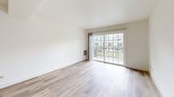 Located at 700 Lincoln Village Circle in Larkspur, CA, this two-story, two-bedroom, two-bathroom home offers a well-designed layout across two floors. The main level features light wood-tone flooring throughout, a bright and open living room with large sliding glass doors that invite natural light and provide views of the surrounding community. A carpeted staircase connects the floors, leading up to the private quarters. The kitchen is thoughtfully appointed with two-tone cabinetry — white upper cabinets paired with gray lower cabinets — complemented by white quartz countertops, a subway tile backsplash, stainless steel appliances, and a window above the sink. Both bedrooms are located on the upper level and feature plush carpeting, natural light from well-placed windows, and baseboard heating. The primary bedroom includes mirrored sliding closet doors and elevated clerestory windows that enhance the sense of height and airiness. Each bathroom offers clean, modern finishes: one features a subway-tiled tub-shower combination with chrome fixtures, while the other includes a glass-enclosed walk-in shower, wood-look flooring, and a white vanity. The overall aesthetic is bright, clean, and move-in ready.