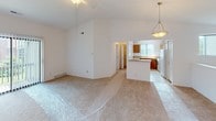 This single-floor home offers a clean, functional layout designed for comfortable everyday living. The main living area is a standout, featuring soaring vaulted ceilings with a ceiling fan that create an airy, open atmosphere. Soft neutral carpet flows throughout the living space, which opens directly into the kitchen area. The kitchen is equipped with warm oak cabinetry, light laminate countertops, a white electric range, and a refrigerator, along with a peninsula that provides additional prep space and a casual dining option. A pendant light fixture adds a finishing touch above the kitchen area.

The home includes multiple bedrooms, each finished with plush carpeting and crisp white walls. One bedroom benefits from a large window with vertical blinds, allowing natural light to brighten the space. Several rooms feature closet access, adding practical storage throughout.

Two full bathrooms serve the home. One features a glass-enclosed walk-in shower, a wood-toned vanity with a light stone-style countertop, and tile flooring. The second bathroom offers a full soaking tub with a shower, a matching wood vanity, and a large mirror with a multi-bulb light bar above.

Overall, the home presents a bright, neutral palette that offers a versatile canvas ready for personalization.