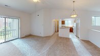 This single-floor home offers a clean, functional layout designed for comfortable everyday living. The main living area is a standout, featuring soaring vaulted ceilings with a ceiling fan that create an airy, open atmosphere. Soft neutral carpet flows throughout the living space, which opens directly into the kitchen area. The kitchen is equipped with warm oak cabinetry, light laminate countertops, a white electric range, and a refrigerator, along with a peninsula that provides additional prep space and a casual dining option. A pendant light fixture adds a finishing touch above the kitchen area.

The home includes multiple bedrooms, each finished with plush carpeting and crisp white walls. One bedroom benefits from a large window with vertical blinds, allowing natural light to brighten the space. Several rooms feature closet access, adding practical storage throughout.

Two full bathrooms serve the home. One features a glass-enclosed walk-in shower, a wood-toned vanity with a light stone-style countertop, and tile flooring. The second bathroom offers a full soaking tub with a shower, a matching wood vanity, and a large mirror with a multi-bulb light bar above.

Overall, the home presents a bright, neutral palette that offers a versatile canvas ready for personalization.