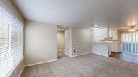 This single-floor, 2-bedroom, 2-bathroom unit offers a practical and comfortable layout designed to maximize livability. The open-concept living and kitchen area forms the heart of the home, with neutral-toned carpet in the living space transitioning to wood-look hard flooring in the kitchen. The galley-style kitchen is well-equipped with ample white cabinetry, generous counter space, a double basin sink, and white appliances including an electric range and refrigerator. A pass-through counter connects the kitchen to the living area, enhancing the sense of openness.

The bedrooms are carpeted and feature neutral walls, providing a calm and versatile backdrop. The primary bedroom offers a comfortable footprint with a sliding double-door closet and a dedicated wall unit. The second bedroom benefits from a window with outdoor views, bringing in natural light. Two full bathrooms, each with a tub-shower combination, wood-look flooring, vanity with sink, and clean white finishes, serve the bedrooms conveniently. Additional highlights include two closets for storage, a dedicated laundry area, and a hallway that efficiently connects all rooms. The overall aesthetic is clean, neutral, and move-in ready.