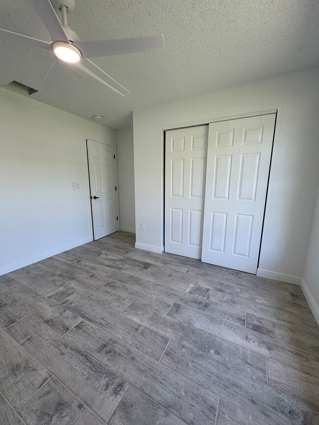 The first bedroom has a spacious closet a ceiling fan and a beautiful view of the front yard. - 4142 Iola Dr