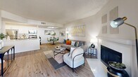 Located at The Del Rey in Las Vegas, Nevada, this single-story, three-bedroom, two-bathroom residence offers a well-designed layout with a bright, neutral palette and wood-style flooring throughout. The welcoming living room serves as the heart of the home, featuring a fireplace, a textured ceiling, and a sliding glass door that opens to a private patio with pleasant outdoor views, allowing natural light to fill the space. The galley-style kitchen is thoughtfully updated with two-tone grey and white cabinetry, white quartz countertops, stainless steel appliances including a refrigerator, range, and microwave, and recessed lighting. Three comfortable bedrooms feature wood-style flooring, textured ceilings, ceiling fans, and windows that bring in natural light. The primary bedroom offers a generous footprint, while the additional bedrooms provide versatile space. Both bathrooms are finished with clean, white tiled tub-shower combinations. A dedicated laundry area houses a full-size washer and dryer, adding everyday convenience. Two closets provide ample storage throughout. The overall ambiance is modern, clean, and move-in ready, making this a functional and stylish home.
