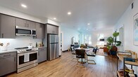 Located on Oakland Blvd in Walnut Creek, CA, this single-floor residence offers a thoughtfully designed interior with a clean, contemporary aesthetic. The open-concept layout seamlessly connects the kitchen, dining, and living areas, creating a spacious and functional flow throughout the main living space. Warm-toned hardwood-style flooring runs throughout, complementing the bright white walls and recessed lighting.

The kitchen is well-appointed with flat-front gray cabinetry, stone-look countertops, a white subway tile backsplash, and a full suite of stainless steel appliances, including a refrigerator, range, microwave, and dishwasher. The adjacent dining area transitions naturally into the living room, which benefits from multiple windows offering views of the surrounding landscaping and outdoor areas, allowing ample natural light to fill the space.

The bedroom features large windows with sheer curtains, wood-style flooring, and a calm, neutral palette. Built-in shelving provides additional storage. Two bathrooms are finished with gray vanities, stone-look countertops, large mirrors, and wood-style flooring; one includes a glass-enclosed walk-in shower.