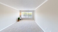 Located at 1100 Pulaski St in Columbia, SC, this 2-bedroom, 2-bathroom residence offers a thoughtfully designed single-floor layout with a clean, modern aesthetic throughout. The open kitchen and living area serve as the heart of the home, where the kitchen showcases granite countertops, white cabinetry with brushed nickel hardware, a classic subway tile backsplash, and a full suite of stainless steel appliances. A peninsula with pendant lighting connects seamlessly to the dining area, accented by crown molding and light hardwood-style flooring. The spacious living room is bathed in natural light from large windows and features plush carpeting and textured ceilings with crown molding details. Both bedrooms offer comfortable proportions with soft carpet underfoot and ample natural light. The primary bedroom includes a mirrored sliding-door closet, providing generous storage. Each bathroom is finished with granite-topped white vanities, brushed nickel fixtures, and hardwood-style flooring, with one bathroom offering a full tub/shower combination. A dedicated in-unit laundry area with wire shelving adds everyday convenience to this well-appointed residence.
