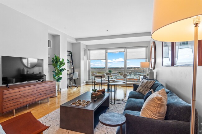 Living room flooded with natural light at The Amelia Apartments in Quincy, MA - Amelia