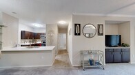 Located in Atlanta, GA, this single-floor, 2-bedroom, 2-bathroom residence offers a thoughtfully designed layout that balances comfort and functionality. The open-plan living and dining area features plush carpeting, crown molding, and a ceiling fan, with sliding glass doors that invite natural light and provide access to an outdoor space. A mirrored accent wall in the dining area adds a sense of depth and brightness to the space.

The kitchen is outfitted with rich dark wood cabinetry, stainless steel appliances including a range, microwave, and refrigerator, contrasted by light quartz countertops and a tile backsplash. A breakfast bar peninsula connects the kitchen seamlessly to the dining and living areas.

The primary bedroom is a comfortable retreat with carpeted flooring and ample room for furnishings. The second bedroom also features carpet, a ceiling fan, and a window with natural light. Both bathrooms are well-finished; the primary bath includes wood-look vinyl flooring, a soaking tub, and a vanity with granite countertops.

A dedicated in-unit laundry room accommodates a full-size washer and dryer with additional shelving. Two closets provide generous storage throughout the home, rounding out this well-equipped residence.