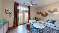 Located at 11335 N Michigan Rd in Carmel, Indiana, this well-appointed one-bedroom, one-bathroom residence offers a smart, efficiently designed floor plan that maximizes every square foot. The open-concept living and kitchen area serves as the heart of the home, where warm hardwood-style flooring flows throughout. The living room is bright and welcoming, anchored by a ceiling fan and French doors that open to a private outdoor patio, flooding the space with natural light. The kitchen is a standout feature, showcasing white shaker cabinetry, a classic subway tile backsplash, quartz countertops, and stainless steel appliances including a gas range, over-the-range microwave, and French door refrigerator. A spacious island with seating provides both additional prep space and a casual dining option, illuminated by elegant globe pendant lights. The generously sized primary bedroom offers plush carpeting, a ceiling fan, and ample room for a full furniture arrangement, complemented by a dedicated closet. The bathroom features wood-look tile flooring, a white vanity with clean lines, and a full tub and shower with stylish gray tile surround. Every detail of this residence reflects a modern, cohesive aesthetic.