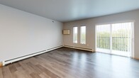 Located at 1418 First Ave N in Fargo, North Dakota, this well-designed one-bedroom, one-bathroom unit offers a functional and modern living experience across a single floor. The open-concept layout seamlessly connects the kitchen and living room, creating a bright and airy atmosphere enhanced by large windows and a sliding glass door that invite generous natural light into the space.

The kitchen is a standout feature, equipped with stainless steel appliances including a refrigerator, range, microwave, and dishwasher. Rich, two-toned cabinetry — warm wood uppers paired with slate-blue lower cabinets — sits against clean light countertops, all accented by recessed ceiling lighting that adds a polished touch.

The living area is spacious and open, with wide-plank wood-look flooring that flows consistently throughout the unit, tying all rooms together with a cohesive, contemporary feel. Baseboard heating is present throughout.

The bedroom offers a comfortable footprint with its own walk-in closet featuring built-in wire shelving, providing ample storage. The bathroom includes a clean, all-white stand-alone shower unit. A dedicated laundry room with a stacked washer and dryer adds exceptional in-unit convenience, rounding out this efficiently designed and move-in-ready home.