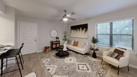 Located at 1500 Willow Trail Dr in Norcross, GA, this two-bedroom, one-bathroom single-floor residence offers a well-organized layout designed to maximize comfort and functionality. The combined kitchen and living room serves as the heart of the home, where light wood-look flooring, neutral walls, and a ceiling fan create a bright and airy atmosphere. Multiple windows invite natural light throughout, with a sliding glass door in the primary bedroom opening to outdoor views. The living area provides ample space for seating and entertaining, with a welcoming, cohesive aesthetic. The kitchen features white shaker-style cabinetry, light quartz countertops, a grey subway tile backsplash, a stainless steel sink, and stainless steel appliances including a range, microwave, dishwasher, and refrigerator. The primary bedroom is generously sized, finished with plush carpet, a ceiling fan, and access to both a walk-in closet and the shared bathroom. The second bedroom also offers comfortable proportions with its own ceiling fan. The full bathroom includes a tub-shower combination with white tile surround. Two closets throughout the home provide practical storage solutions for everyday living.