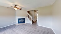 Located at 3818 S Rock Quarry Rd in Columbia, MO, this two-story, 2-bedroom, 3-bathroom home offers a functional and comfortable layout spread across two floors. The main level features a bright living room with light gray luxury vinyl plank flooring, a ceiling fan, and a tiled fireplace with a classic wood mantel — a warm focal point for the space. A staircase with white-painted railings connects the floors seamlessly. The kitchen is well-equipped with warm oak cabinetry, light countertops, and black appliances including a refrigerator, range, microwave, and dishwasher. A window above the sink brings in natural light. Just off the kitchen, a dedicated laundry area with a full-size washer and dryer adds everyday convenience. A half bath on the main level serves guests. Upstairs, both bedrooms are carpeted and feature neutral tones, generous closets with built-in rods, and access to private bathrooms. The spacious primary bedroom offers a ceiling fan and a window with pleasant outdoor views of green surroundings. Two full bathrooms upstairs include tub/shower combos with clean white surrounds. Textured ceilings and neutral wall colors throughout create a cohesive, move-in-ready atmosphere.