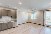 Located on E Main Street in Chattanooga, TN, this modern one-bedroom, one-bathroom unit offers a thoughtfully designed layout with contemporary finishes throughout. Light hardwood flooring and recessed lighting run throughout the space, creating a clean, cohesive aesthetic.

The open-concept kitchen and living area serves as the heart of the unit. The kitchen is well-appointed with taupe flat-front cabinetry, granite countertops, a subway tile backsplash, and a full suite of stainless steel appliances, including a refrigerator, range, microwave, and dishwasher. The living area flows naturally from the kitchen and features a ceiling fan and a window with outdoor views, allowing natural light to fill the space.

The bedroom is a comfortable, well-proportioned room with its own ceiling fan, a window overlooking the surroundings, and access to a dedicated closet. The clean, neutral walls provide a calm and versatile environment.

The full bathroom features a granite-topped dual-sink vanity with modern hardware, a large mirror, recessed lighting, and a full tub/shower combination with built-in shelving. The unit also includes an in-unit laundry area, adding everyday convenience. The overall design is modern, minimal, and move-in ready.