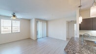 Located at 455 South Recker Road in Gilbert, AZ, this single-story, 2-bedroom, 2-bathroom home offers a well-designed layout with modern finishes throughout. The open-concept living and kitchen area serves as the heart of the home, featuring light wood-style flooring, neutral tones, and a sliding glass door with vertical blinds that invites natural light. The kitchen is outfitted with dark espresso cabinetry, granite countertops, stainless steel appliances including a refrigerator, range, microwave, and dishwasher, and pendant lighting overhead. The spacious primary bedroom includes a ceiling fan, a window with outdoor views, and access to a generous walk-in closet with built-in shelving and multiple hanging rods. The second bedroom is finished with plush carpet and a glass-paneled exterior door. Both bathrooms are sleek and modern; the primary bath features a dual-sink vanity with dark cabinetry, white countertops, and a large mirror, while the second bath includes a full tub-shower combo and matching finishes. A dedicated laundry room with side-by-side washer and dryer hookups and overhead shelving adds everyday convenience to this well-appointed home.