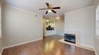 This well-appointed 4-bedroom, 4-bathroom home in San Antonio's 78209 zip code spans three floors, offering a thoughtfully designed layout with generous living space throughout. The ground level provides direct access to an attached garage with automatic opener and a staircase leading to the main living areas above.

The primary living floor features rich hardwood flooring flowing through an open-concept living and dining area anchored by a tiled fireplace. The kitchen is outfitted with dark granite countertops, a curved breakfast bar, stainless steel appliances including a refrigerator, white cabinetry, and a mosaic tile backsplash. A ceiling fan with crown molding trim adds a polished touch to the living room.

The bedrooms are distributed across the upper floors, each equipped with ceiling fans. The primary bedroom benefits from multiple windows that fill the room with natural light and hardwood flooring, while additional bedrooms feature plush carpet and built-in window seating. Seven closets, including a spacious walk-in with wire shelving, provide abundant storage. The bathrooms feature granite vanity tops, white cabinetry, and tub-shower combinations. A dedicated laundry area with a full-size washer and dryer adds convenience, and a private balcony completes this multi-level home.
