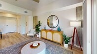 Located in Winter Haven, Florida, this thoughtfully designed 2-bedroom, 2-bathroom residence offers a modern aesthetic across a well-utilized single floor. Light wood-style flooring runs throughout, lending warmth and continuity to the space.

The open-concept kitchen is a standout feature, boasting crisp white cabinetry with matte black hardware, bright white countertops, a subway tile backsplash, and a full suite of stainless steel appliances. A central island with seating provides additional workspace and a casual dining option, while track lighting overhead enhances both functionality and ambiance.

The kitchen flows seamlessly into the living room, which is bathed in natural light from large sliding glass doors that open to a private balcony with outdoor views. Exposed concrete columns add an industrial architectural accent throughout the living areas.

The spacious primary bedroom features a generous closet, light-filled window with tree views, a ceiling fan, and access to a well-appointed en-suite bathroom complete with a single vanity and glass-enclosed shower. The second bedroom is equally comfortable, with its own closet. The second bathroom offers a full tub-shower combination with white tile surround and a white vanity. Both bathrooms continue the wood-style flooring found throughout the residence.
