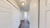 This one-bedroom, one-bathroom unit at 370 W Hopkins Ave in Pontiac, Michigan offers a practical and straightforward layout across a single floor. The combined living and dining area is generously proportioned, featuring soft carpeting, white walls, and a large window dressed with vertical blinds that allows natural light to brighten the space. A baseboard heating system runs along the perimeter walls, providing efficient warmth throughout.

The galley-style kitchen is well-equipped with warm wood-toned cabinetry above and below the counters, a stainless steel sink, and white appliances including a range and full-size refrigerator. Durable hardwood-style flooring completes the kitchen's clean, functional aesthetic.

The bedroom offers a comfortable amount of space, complete with soft carpet, a window-mounted air conditioning unit, and a built-in closet with paneled double doors. The unit is notable for its four closets in total, providing ample storage throughout. A hallway connects the main areas of the home and features an additional closet.

The bathroom is clean and straightforward, featuring a full tub-shower combination with white tile surround and a shower curtain rod. Throughout the unit, white walls and flush-mount ceiling lighting maintain a bright, neutral atmosphere well-suited for personalizing.