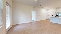 This 950-square-foot, single-story residence in North Augusta, SC features 2 bedrooms and 2 bathrooms with a clean, modern aesthetic carried consistently throughout. Light wood-look luxury vinyl flooring flows across the entire unit, complemented by crisp white walls and bright recessed lighting. The open-concept kitchen is a standout, boasting white shaker cabinetry with matte black hardware, a white quartz countertop island with an undermount sink, subway tile backsplash, and stainless steel appliances including a French door refrigerator with ice maker, electric range, microwave, and dishwasher. The spacious living area connects seamlessly to the kitchen, offering an open and airy layout. Both bedrooms feature large windows with blinds that invite natural light and outdoor views of surrounding greenery. The primary bedroom measures 150 square feet and includes a dedicated closet. The primary bathroom is well-appointed with a white shaker vanity, quartz countertop, matte black fixtures, and built-in open shelving. The second bathroom includes a tiled tub-shower combo, white vanity, and matching black hardware. A wire-rack closet provides additional storage. The unit's consistent modern finishes and efficient layout make it a functional and stylish living space.