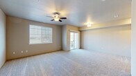 Located in Central Point, Oregon, this two-story, two-bedroom, two-bathroom home offers a well-organized layout spread across two comfortable floors. The main level features a carpeted living area with a ceiling fan, abundant natural light from large windows with blinds, and a sliding glass door that opens to a private balcony. A staircase with small pass-through windows connects the floors, adding an architectural detail to the open feel of the entry area. The kitchen is well-appointed with white shaker-style cabinetry, light countertops, black appliances including a range, microwave, and refrigerator, and hardwood-style flooring that carries through to the adjacent laundry room. The dedicated laundry room includes a full-size washer and dryer with overhead shelving. Upstairs, the generously sized primary bedroom features carpet flooring, multiple windows for natural light, and direct access to a private en-suite bathroom with a single vanity and hardwood-style floors. The second bedroom is also carpeted and well-lit with wide windows. Both bathrooms are clean and functional, with one featuring a tub/shower combination. Each bedroom benefits from its own closet, rounding out this practical and comfortable two-story home.