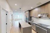 Located in the heart of downtown Calgary at 736 8 Ave SW, this modern 2-bedroom, 1-bathroom unit offers a well-designed layout with contemporary finishes throughout. Light hardwood flooring flows seamlessly across the single-level floor plan, creating a bright and cohesive aesthetic.

The kitchen is a standout feature, showcasing a thoughtful combination of warm wood-grain upper cabinetry and matte grey lower cabinets, set against a classic white subway tile backsplash. A central island with a crisp white quartz countertop provides additional prep space and casual seating. Stainless steel appliances, including a French door refrigerator, double wall oven, dishwasher, and induction cooktop, complete the chef-inspired space. A linear pendant light above the island adds a refined modern touch.

The open living area extends naturally from the kitchen, bathed in natural light from large windows offering urban Calgary views. Both bedrooms are well-proportioned, with the primary bedroom featuring floor-to-ceiling mirrored sliding closet doors and a large window overlooking the cityscape.

The bathroom is finished in a clean, minimalist style with white marble-look tile on both the floors and shower walls, complemented by matte black fixtures and a grey vanity. Additional conveniences include in-unit laundry and ample closet storage throughout.