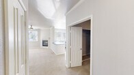 Located at 2 Enterprise in Aliso Viejo, California, this single-floor residence offers a well-designed layout with a bright, open feel throughout. The living area is a welcoming centerpiece, featuring soft carpeting, crown molding, a ceiling fan, and a classic fireplace with a white mantel. Multiple windows allow abundant natural light to fill the space, with views of surrounding greenery. An adjoining area with a large window and outdoor access further extends the living space.

The kitchen is thoughtfully appointed with white shaker-style cabinetry, a subway tile backsplash, granite-style countertops, and a full suite of stainless steel appliances including a refrigerator, range, microwave, and dishwasher. A large window above the sink brings in ample daylight, and a breakfast bar connects the kitchen to the living area.

The bedrooms are carpeted and bright, each featuring ceiling fans and windows with blinds. Closet space is generous, with one bedroom offering a walk-in closet and another featuring mirrored sliding-door closets with built-in shelving. The bathroom is finished with wood-look flooring, a white vanity with contemporary fixtures, and a full tub-shower combination. A dedicated in-unit laundry area accommodates a full-size washer and dryer.