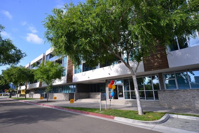 Bonita acera bordeada de árboles frente a los lofts de 12th Street en National City, California. - 12th Street Lofts