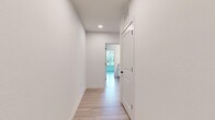 Located at 3014 Dr. Martin Luther King Jr. St. S in Saint Petersburg, FL, this well-appointed 2-bedroom, 2-bathroom single-story home offers a clean, modern aesthetic throughout. Light wood-tone flooring runs continuously across every room, creating a cohesive and airy feel. The open kitchen is a standout feature, showcasing white shaker cabinetry, granite countertops, a large central island with pendant lighting, and a full suite of stainless steel appliances. The kitchen flows naturally into the living area, making the combined space ideal for everyday living and entertaining. Both bedrooms are generously sized and benefit from multiple windows that invite abundant natural light and views of the surrounding greenery. Ceiling fans are featured in the bedrooms for added comfort. Each bedroom is served by its own closet with built-in wire shelving, offering practical storage solutions. The two bathrooms continue the home's clean design language, featuring white cabinetry with matte black hardware and granite-topped vanities. A bright, well-lit hallway with recessed lighting connects the living spaces to the private quarters. The overall ambiance is fresh, modern, and move-in ready, reflecting thoughtful design choices throughout.