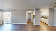 Located at 905 Bryan Pl in Garner, NC, this two-bedroom, two-bathroom residence offers a practical and well-appointed single-floor layout. The combined living and dining area is bright and open, featuring wood-style flooring, neutral gray walls, and a textured ceiling. Sliding glass doors flood the space with natural light and open directly onto a private balcony with outdoor views, creating a seamless indoor-outdoor connection. An additional window further enhances the natural light throughout.

The galley-style kitchen is efficiently designed with white cabinetry lining both sides, a mosaic tile backsplash, dark countertops, stainless steel appliances including a refrigerator and dishwasher, and a double-basin sink. A utility and laundry area is conveniently accessible from the kitchen.

Both bedrooms offer wood-style flooring and generous closet space, with the primary bedroom featuring a notably spacious layout and ample storage across multiple closets. The two bathrooms each include a full tub-and-shower combination with clean white surrounds. A central hallway connects all areas of the home efficiently. Throughout the residence, a consistent neutral palette and durable flooring create a cohesive, move-in-ready ambiance.
