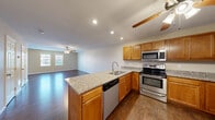 This two-story, two-bedroom, two-bathroom home at 522 Blackstone Drive in Morgantown, WV offers a well-designed layout spread across two floors. The main level features an open-concept kitchen and living area, where rich hardwood flooring flows seamlessly throughout. The kitchen is equipped with stainless steel appliances — including a refrigerator, range, microwave, and dishwasher — complemented by warm honey-toned cabinetry, granite countertops, and a peninsula that doubles as additional prep and dining space. Recessed lighting and ceiling fans provide both function and comfort throughout the living area, which is bright and open with views to a balcony. The upper level hosts the two bedrooms, each with hardwood floors, ceiling fans, and generous closet access. The spacious primary bedroom includes a private balcony with scenic wooded views, adding a serene outdoor retreat. Both bathrooms feature tiled flooring and full tub-shower combinations. A dedicated laundry area and ample closet storage add everyday convenience. A carpeted staircase connects the two levels, and the overall neutral color palette creates a clean, move-in-ready atmosphere throughout the home.