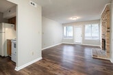 Located at 632 23rd St E in Tuscaloosa, Alabama, this single-story home offers a well-organized layout with consistent finishes throughout. Dark hardwood-style flooring runs through the living areas, bedrooms, and hallways, providing a cohesive look across the entire space. A long, well-lit hallway connects the main living areas to the bedrooms, lined with neutral gray walls and clean white baseboards. The living room is generously sized, featuring large windows and a glass-paneled door that allows natural light to fill the space. The galley-style kitchen is equipped with warm wood cabinetry, light countertops, a double sink, and a white electric range, with an adjacent windowed area that enhances the feel of the space. The bedrooms are well-proportioned, each featuring windows with blinds that bring in natural light, textured ceilings, and the same dark flooring found throughout the home. Two bathrooms serve the residence — one features a white vanity with a framed mirror and separate water closet, while the other includes a full bathtub and shower combination with rich, earth-toned stone-look wall surrounds, a white vanity, and wood-style flooring. Textured ceilings are present in most rooms, and the neutral color palette throughout creates a clean, move-in-ready atmosphere.