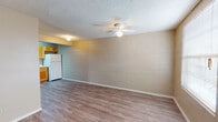 Located at 8017 San Jose Rd in El Paso, TX, this single-floor unit offers a straightforward and functional layout designed for comfortable everyday living. Throughout the space, durable wood-look laminate flooring provides a cohesive and easy-to-maintain surface, complemented by painted cinder block walls that lend a sturdy, industrial character to the interior.

The open living area is bright and airy, anchored by a ceiling fan with integrated lighting and a textured ceiling. Natural light filters in through blinded windows, creating a welcoming atmosphere. The kitchen is efficiently designed with warm honey-toned wood cabinetry — both upper and lower — offering generous storage space. Light countertops, a double-basin sink, a white electric coil-burner range with overhead ventilation, and a full-size refrigerator complete the kitchen's practical setup.

The bathroom features a wide vanity with warm wood cabinetry and a single basin sink, while the toilet is housed in a separate compartment for added privacy. Bedrooms are well-proportioned, with cinder block accent walls in some rooms, wood-look flooring, and windows dressed with blinds to allow for natural light and privacy. The space is served by a central floor vent system, ensuring year-round climate comfort throughout the unit.