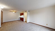 Located at 1000 S Basswood Cir in Bloomington, Indiana, this single-floor, two-bedroom unit offers a practical and well-organized layout across a compact but efficiently designed footprint. The open living and dining area is carpeted and features a ceiling fan, creating a comfortable, functional common space. Adjacent to the living area, the kitchen is outfitted with warm wood cabinetry, white appliances including a range, refrigerator, and microwave, along with a double-basin sink and light countertops. A pass-through opening connects the kitchen to the living and dining areas, enhancing the sense of openness. Two hallways guide residents to the private areas of the unit, which include two carpeted bedrooms. The spacious primary bedroom features a ceiling fan and a double-door closet, while the second bedroom offers natural light through a window with outdoor greenery views. Three closets throughout the unit provide ample storage. The bathroom features slate-style tile flooring and a wood-toned vanity. An in-unit laundry area adds everyday convenience. Textured ceilings and warm wood-toned trim and doors carry a consistent, cohesive aesthetic throughout the unit.