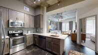 Located at 425 N Boylan Ave in Raleigh, NC, this one-bedroom, one-bathroom unit showcases a striking industrial-chic aesthetic defined by soaring exposed concrete ceilings, dark polished concrete floors, and an open-concept layout that seamlessly connects the kitchen, dining, and living areas. The well-appointed kitchen is equipped with stainless steel appliances, rich dark-toned cabinetry, white quartz countertops, a subway tile backsplash, and a peninsula with a built-in sink that opens directly to the living space. The living room is bright and airy, benefiting from natural light through large windows and a sliding glass door leading to a private balcony. The bedroom offers a cozy retreat with large windows framing outdoor views, exposed concrete ceiling accents, and ample closet space. The bathroom features a full soaking tub with floor-to-ceiling subway tile surround. Additional conveniences include an in-unit laundry area and a utility room. Two closets provide generous storage throughout. The unit also includes a dedicated dining area, completing this well-designed urban living space.