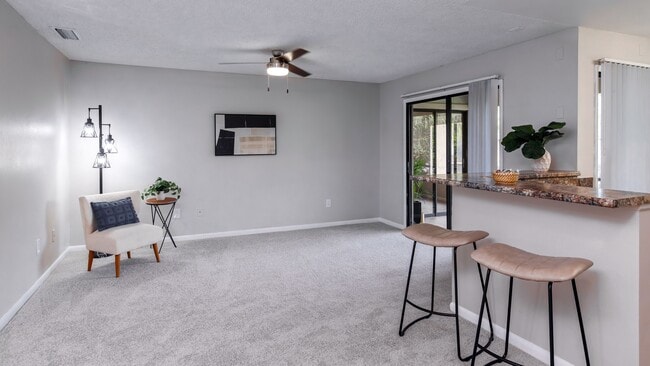 Enjoy the comfort of a spacious, open living featuring plush carpeting, a breakfast bar, and direct access to a screened-in patio. - Harper Grand