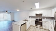Located at 812 Crescent Commons Way in Fayetteville, NC, this single-floor residence offers a clean, contemporary design with a cohesive neutral palette throughout. The kitchen is a standout feature, outfitted with crisp white shaker-style cabinetry, marble-look countertops, and a grey subway tile backsplash that adds texture and visual interest. A full suite of stainless steel appliances — including a refrigerator, electric range, dishwasher, and range hood — provides a polished, functional workspace. A peninsula with an integrated sink extends the counter space and creates a natural transition into the open living area, which is bathed in light and finished with wood-style plank flooring. The living space is airy and versatile, offering an open sightline to the kitchen. The bedroom features a ceiling fan, light wood-style flooring, and direct access to the bathroom. The bathroom is well-appointed with a soaking tub, toilet, and wood-look tile flooring that maintains design consistency with the rest of the home. Throughout the space, white walls and bright lighting create a clean, welcoming ambiance well-suited to a variety of lifestyles.
