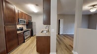 Located at 1290 W Government St in Brandon, Mississippi, this one-bedroom, one-bathroom unit offers a well-organized, single-floor layout designed for comfortable everyday living. The open-concept living, dining, and kitchen area forms the heart of the home, finished with warm wood-look luxury vinyl plank flooring throughout the main spaces. The living room features a ceiling fan and a set of French doors fitted with white plantation blinds, allowing natural light to filter in while offering outdoor access. Neutral gray walls provide a clean, versatile backdrop throughout.

The kitchen is outfitted with rich dark wood cabinetry offering ample storage, granite countertops, a stainless steel undermount sink, and a full suite of stainless steel appliances including a gas range, microwave, and refrigerator. A peninsula-style counter connects the kitchen to the main living area, enhancing the open flow of the space.

The bedroom features plush carpeting, soft neutral tones, and a dedicated closet, providing a comfortable and private retreat. The bathroom includes wood-look flooring, a full bathtub with shower, and a clean, functional layout. The unit's consistent finishes and thoughtful design make it a practical and attractive home in the Brandon area.